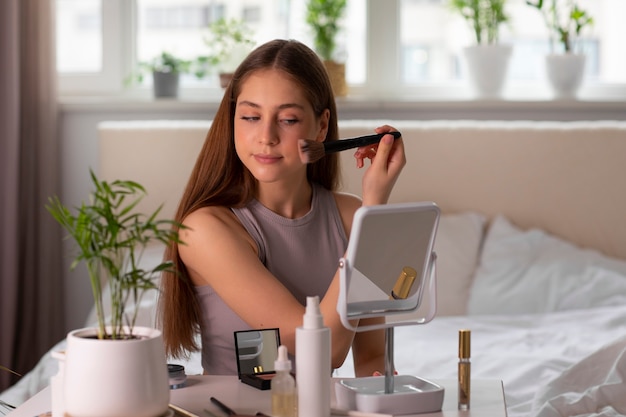 Foto grátis menina de tiro médio colocando maquiagem