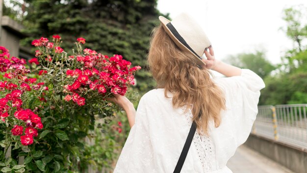 Menina de tiro médio perto de flores