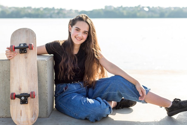 Menina de tiro no escuro, segurando seu skate