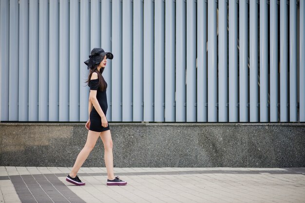 Menina de vestido preto andando fora