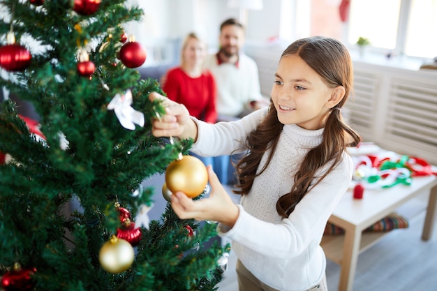 Menina decorando a árvore de natal