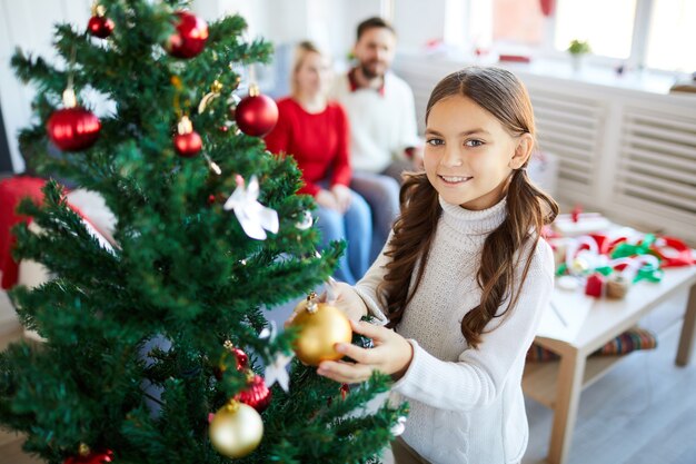 Menina decorando a árvore de natal