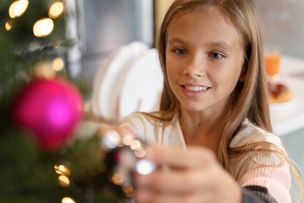 Menina decorando a árvore de natal