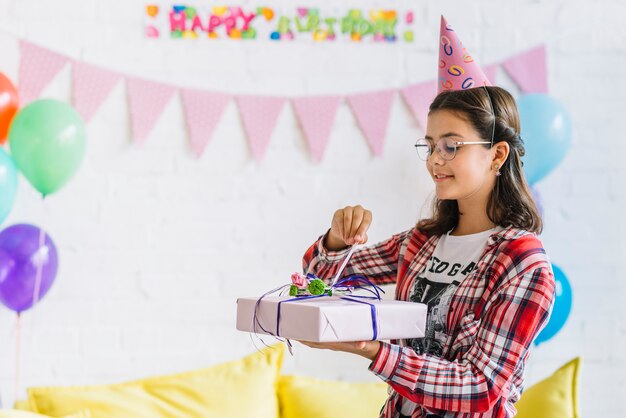 Menina desembrulhando presente de aniversário