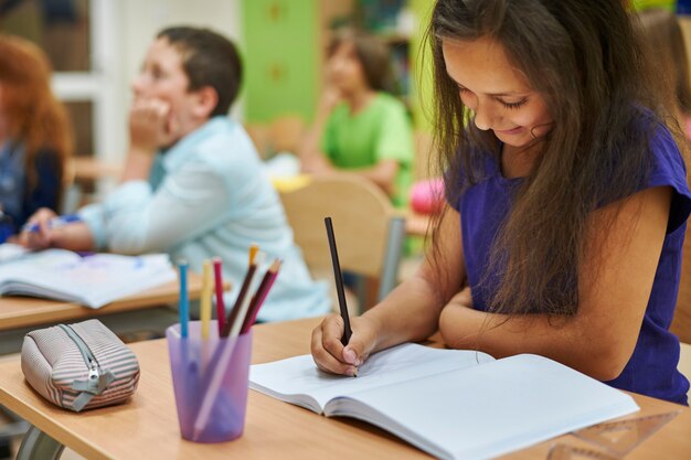 Menina desenhando em seu caderno