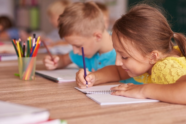 Menina desenhando em seu caderno