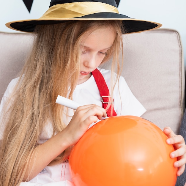 Menina desenhando um balão de halloween