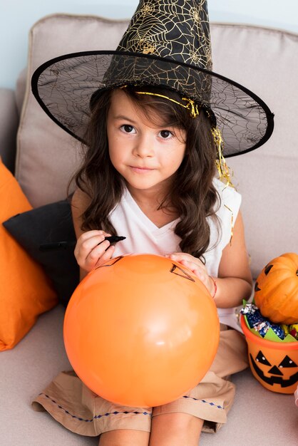 Menina desenhando um balão de halloween