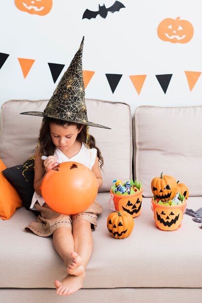 Menina desenhando um balão de halloween