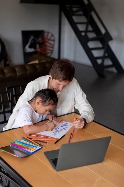 Foto grátis menina desenhando uma mensagem de saudades de você para a mãe dela em uma videochamada