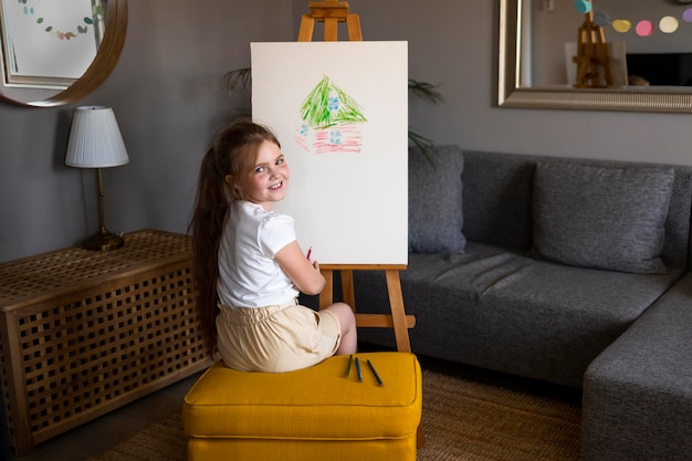 Menina desenhando usando cavalete
