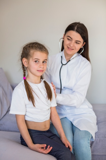 Foto grátis menina doente sendo examinada pelo médico