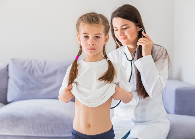 Menina doente sendo examinada pelo médico