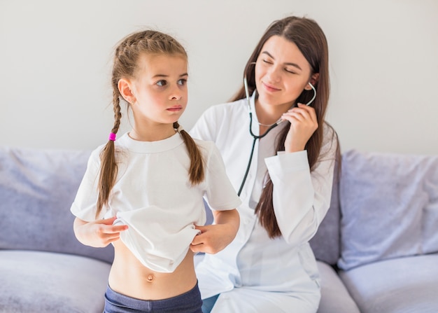 Foto grátis menina doente sendo examinada pelo médico