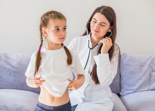 Menina doente sendo examinada pelo médico