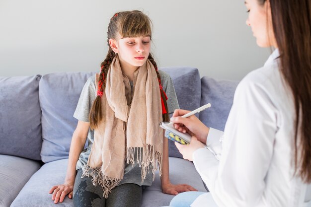 Menina doente sendo examinada pelo médico