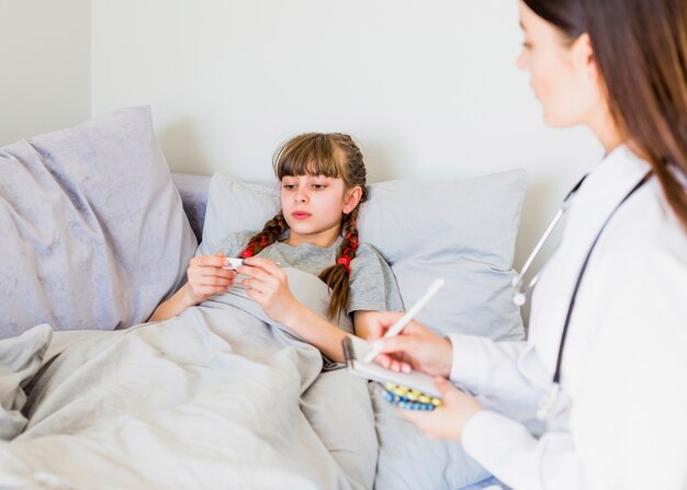 Menina doente sendo examinada pelo médico