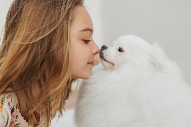 Menina e cachorro tocando o nariz