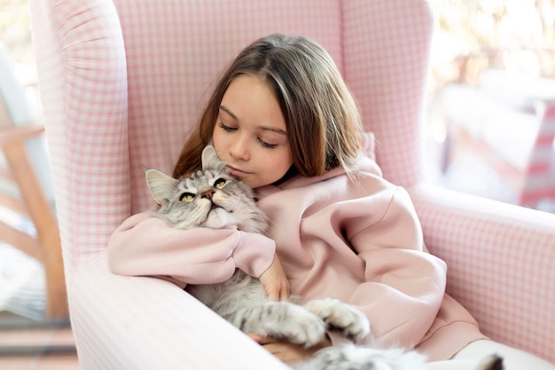 Menina e gato sentados em uma poltrona