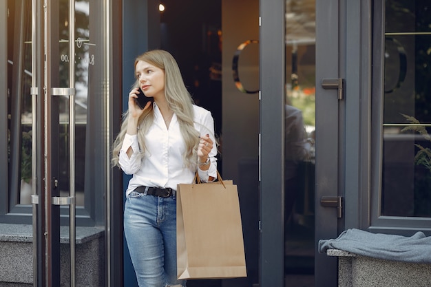 Menina elegante com sacola de compras em uma cidade