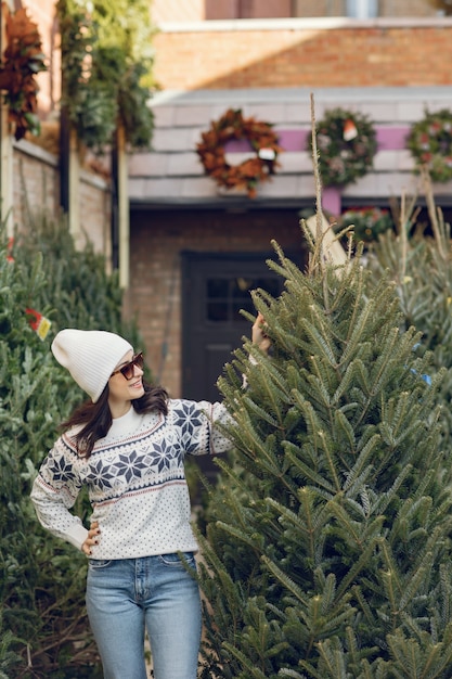 Foto grátis menina elegante compra uma árvore de natal.