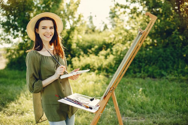 Menina elegante e bonita pintura em um campo