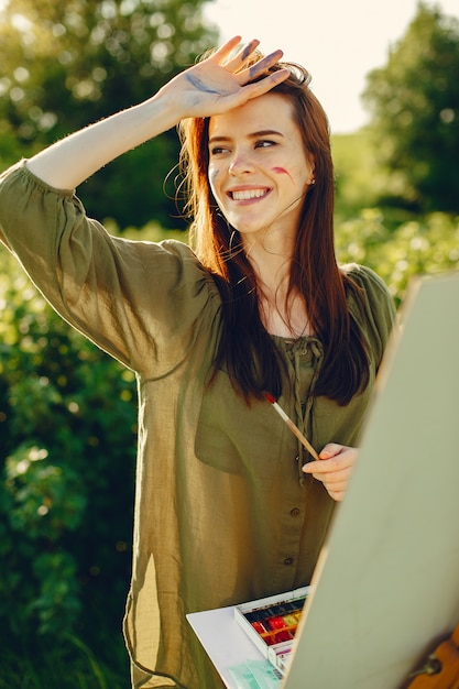 Menina elegante e bonita pintura em um campo