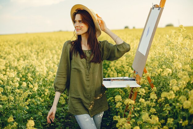 Menina elegante e bonita pintura em um campo