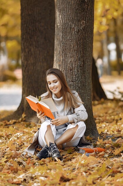 Menina elegante e elegante em um parque de outono