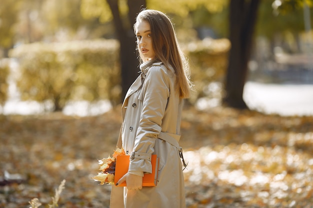 Menina elegante e elegante em um parque de outono