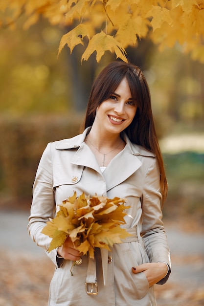 Menina elegante e elegante em um parque de outono