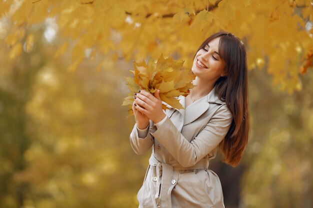 Menina elegante e elegante em um parque de outono