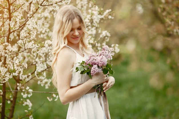 Menina elegante e elegante em um parque de primavera