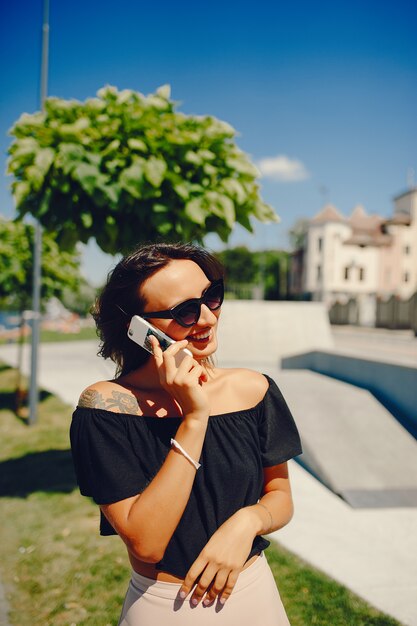 Menina elegante em pé em uma cidade de verão