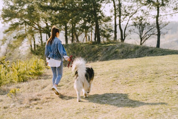 Foto grátis menina elegante em um campo ensolarado com um cachorro