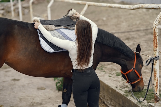 Menina elegante em uma fazenda com um cavalo