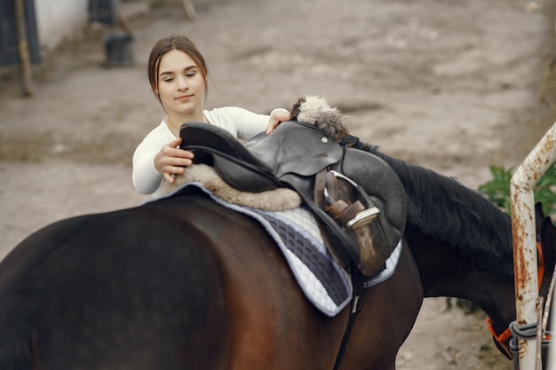 Menina elegante em uma fazenda com um cavalo