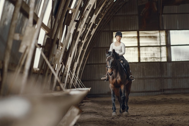 Menina elegante em uma fazenda com um cavalo