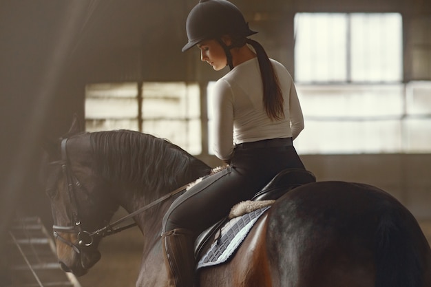 Menina elegante em uma fazenda com um cavalo