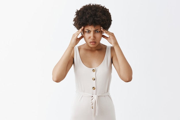 Foto grátis menina elegante pressionada posando contra a parede branca