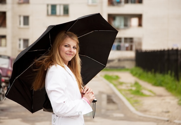 Menina em capa com guarda-chuva