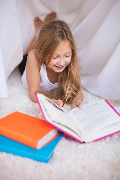 Menina em idade escolar lendo um livro