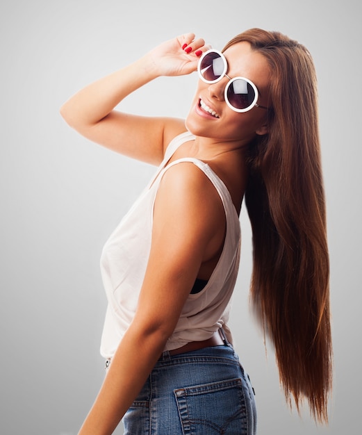 Menina em óculos de sol levanta com sorriso cheio de dentes