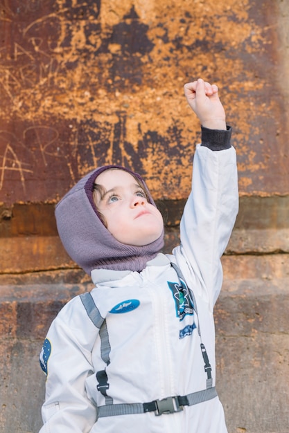 Foto grátis menina em traje espacial de pé com mão acima
