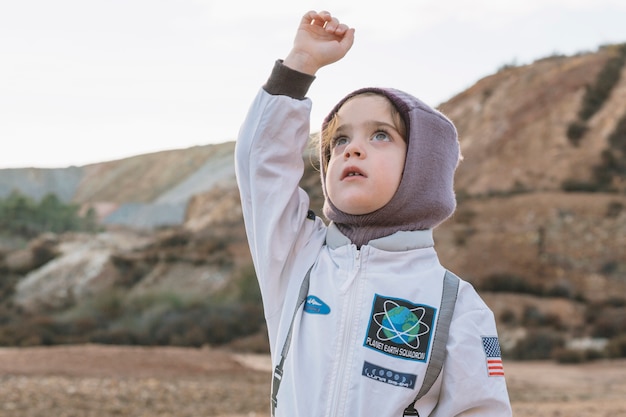 Menina em traje espacial na natureza