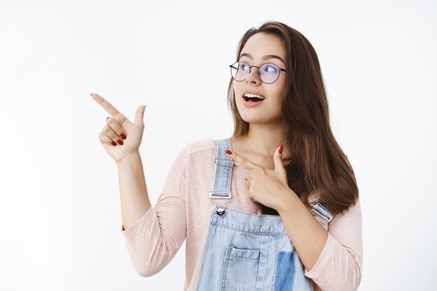 Menina encantadora chamando a atenção no canto superior esquerdo, apontando com o dedo