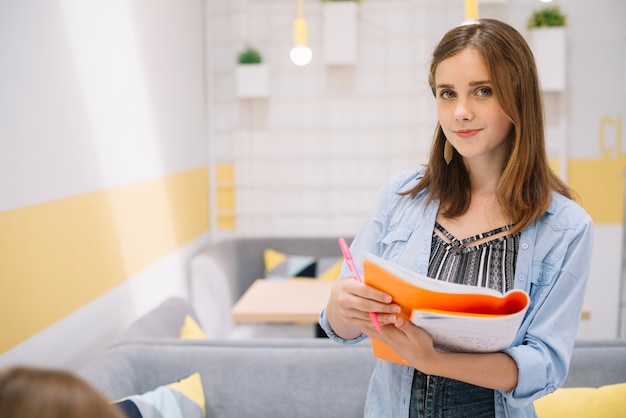 Foto grátis menina encantadora com caderno posando na câmera