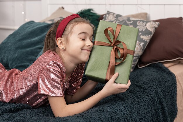 Menina engraçada com uma caixa de presente de natal