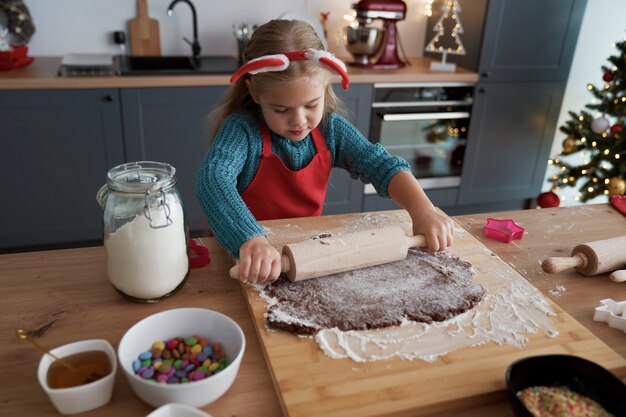 Menina enrolando um pão de gengibre