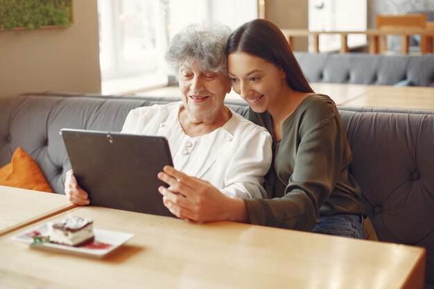 Menina ensinando a avó como usar um tablet